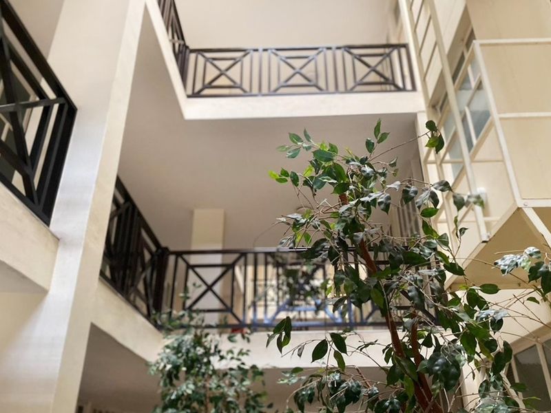 An open-air central atrium or courtyard area featuring multi-level balconies with decorative metal railings.