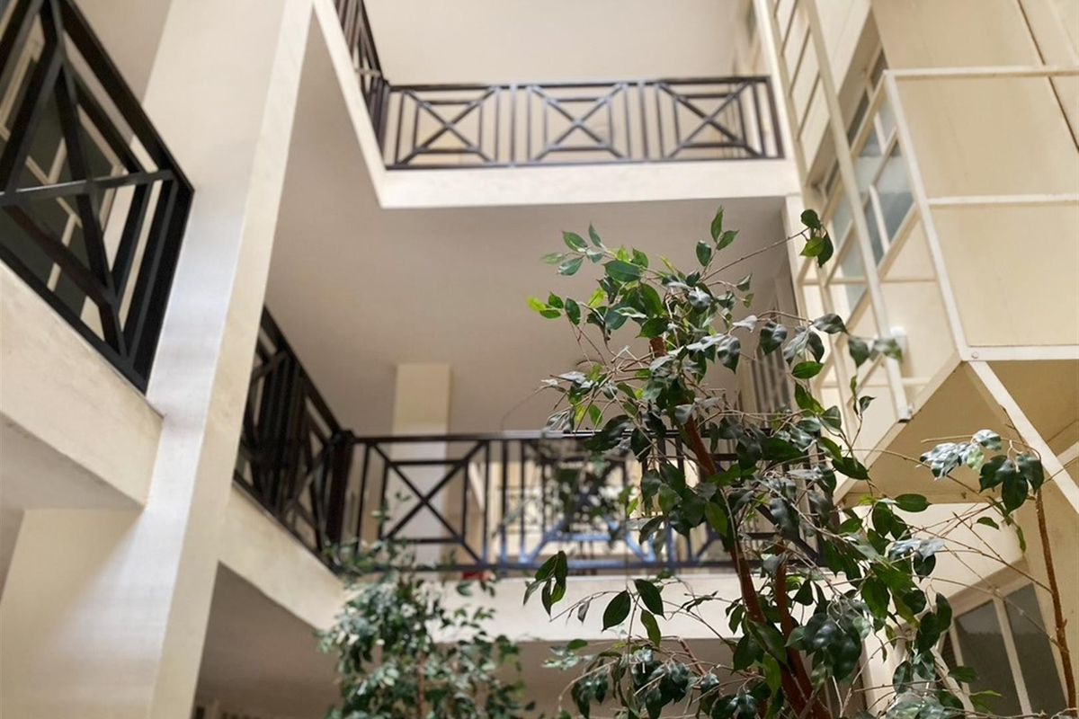 An open-air central atrium or courtyard area featuring multi-level balconies with decorative metal railings.