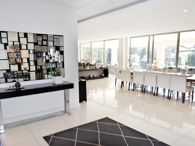 Spacious open-plan living and dining area featuring large format floor tiles, recessed lighting, and expansive sliding glass doors leading to the outdoor space.