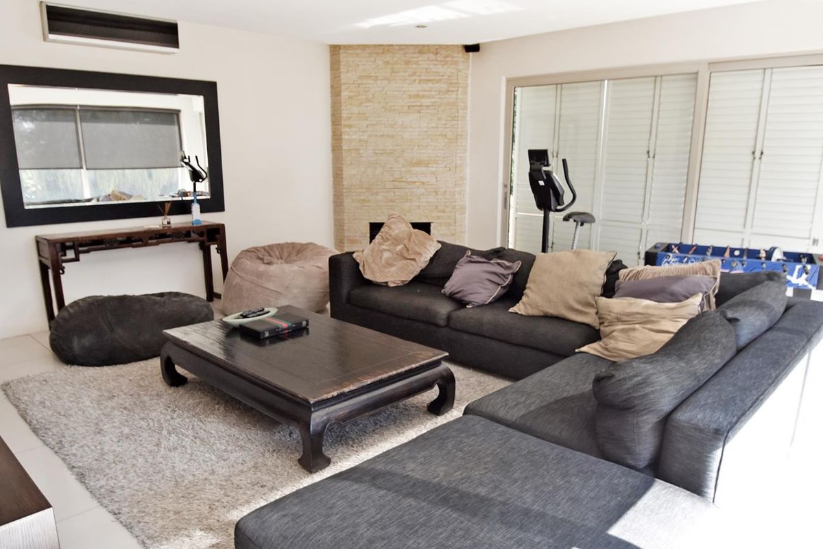 Spacious living room featuring a stone-clad fireplace, split-system air conditioning, and large sliding glass doors providing access to the outdoor area.