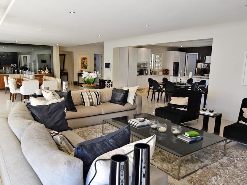 Spacious open-plan living area featuring a modern kitchen with integrated cabinetry, recessed lighting, and polished tiled flooring throughout the connected dining and lounge spaces.