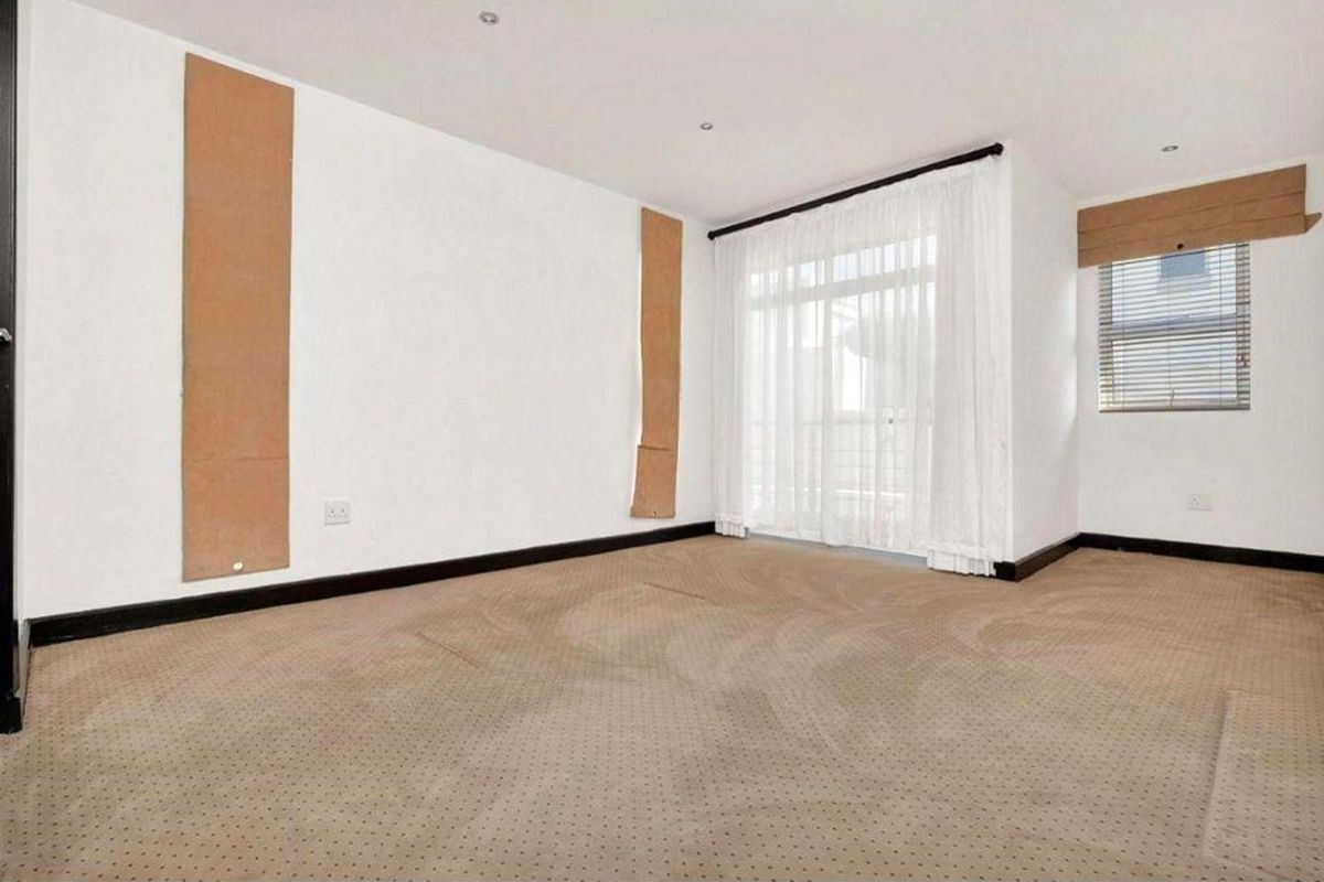 An empty bedroom featuring carpeted flooring, recessed lighting, and a sliding glass door providing access to an outdoor area.
