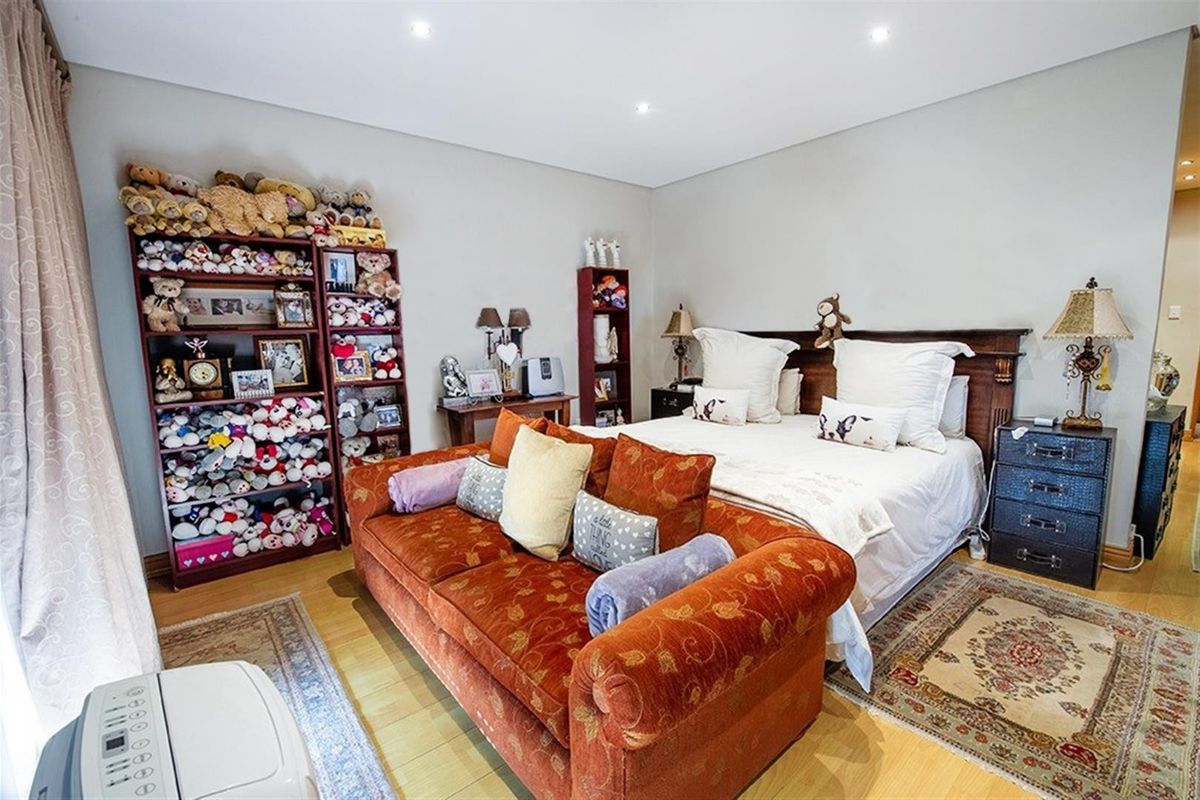 A spacious bedroom featuring laminate flooring and recessed downlighting, offering a comfortable layout with ample room for furniture.
