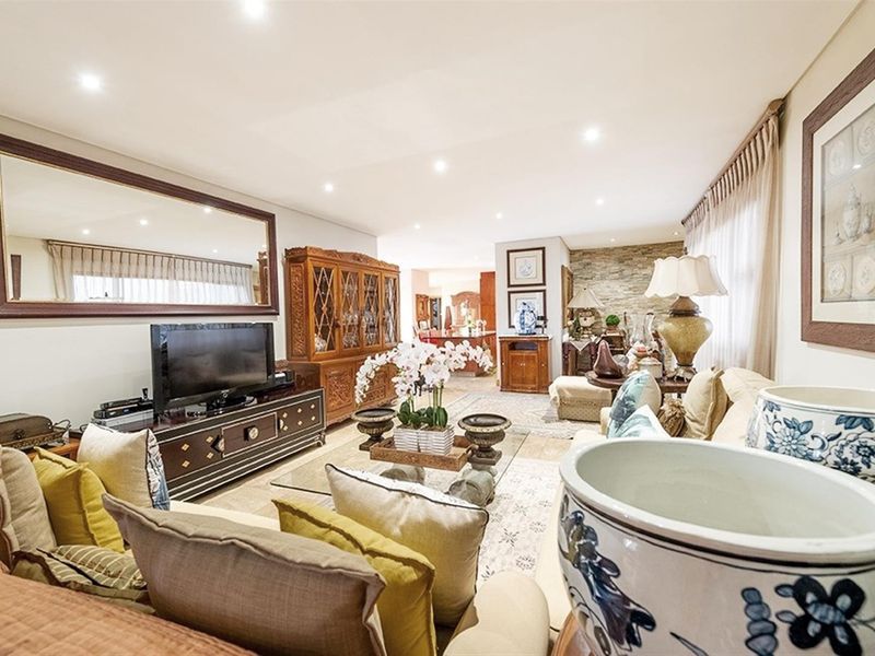 Spacious open-plan living area featuring recessed downlighting, tiled flooring, and a decorative stone feature wall.