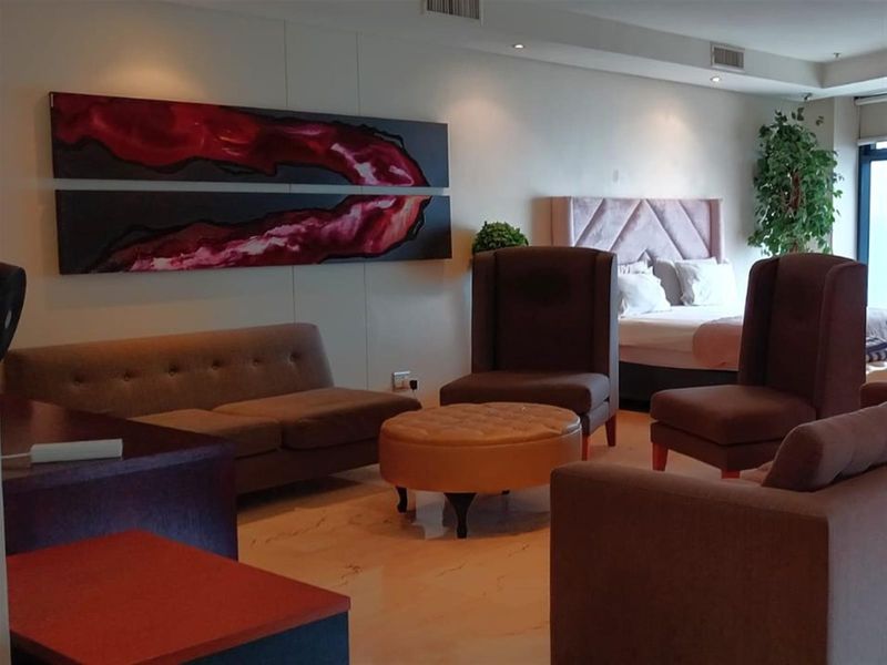 An open-plan living and bedroom area featuring tiled flooring, recessed downlighting, and integrated ducted air conditioning vents.