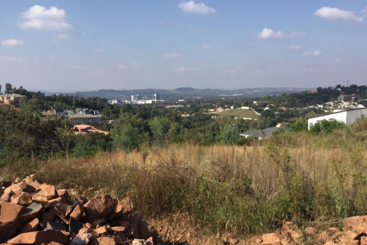 An elevated view overlooking the surrounding landscape and residential area from the vacant commercial land.