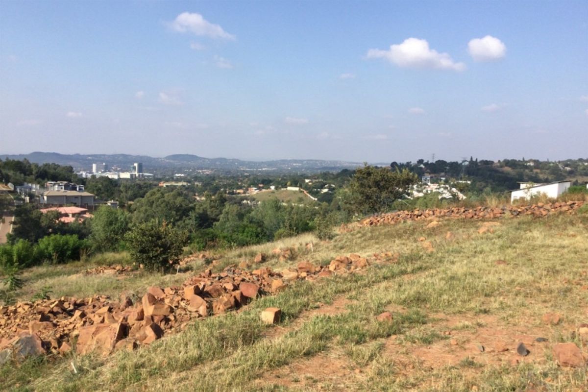 A scenic elevated view overlooking the surrounding landscape and distant urban development from the vacant commercial property.
