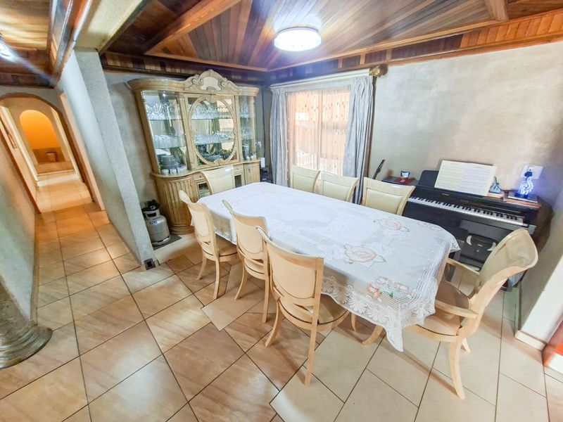 A dining room featuring a distinctive timber-clad vaulted ceiling and ceramic floor tiles, providing a warm and traditional atmosphere.