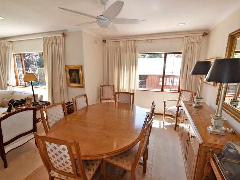 Spacious open-plan living and dining area featuring neutral carpeting, recessed lighting, and a ceiling fan, offering a comfortable and functional layout.