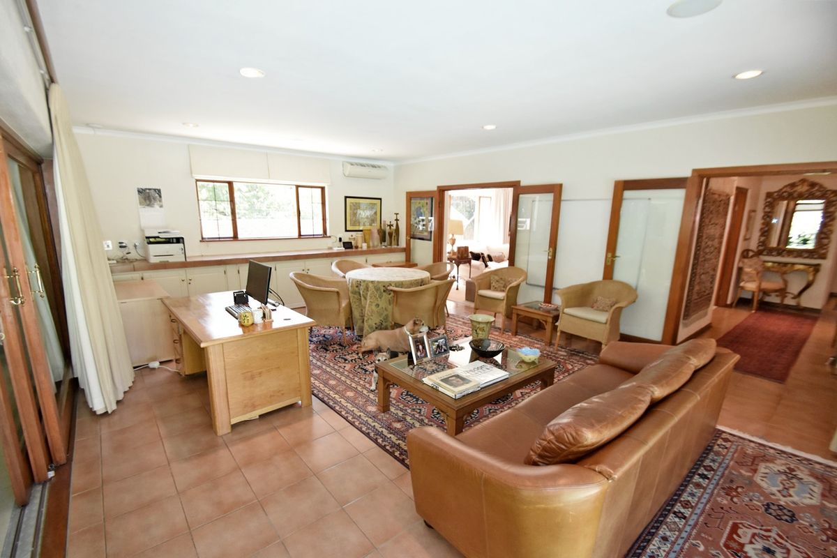 Spacious living area featuring tiled flooring, recessed lighting, built-in cabinetry, and multiple timber-framed glass doors providing access to adjacent rooms.