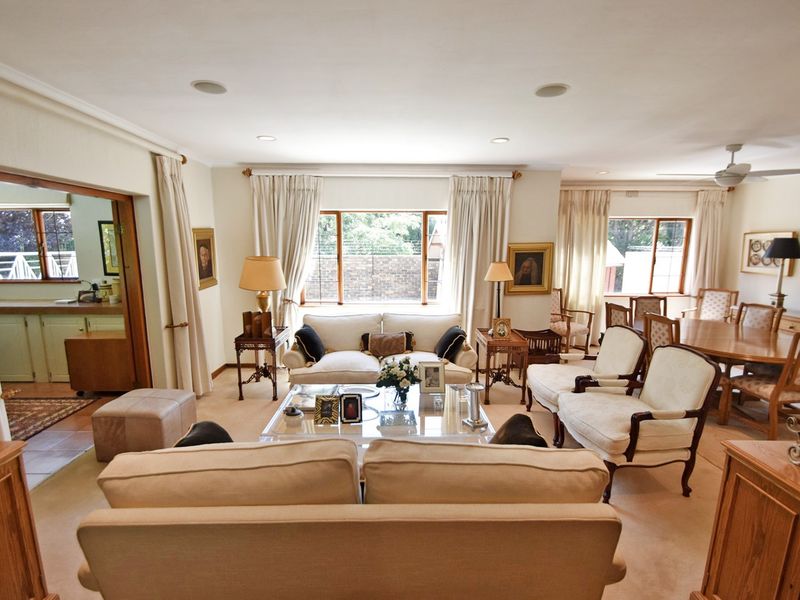 Spacious open-plan living and dining area featuring neutral carpeting, recessed lighting, and large windows allowing for ample natural light.