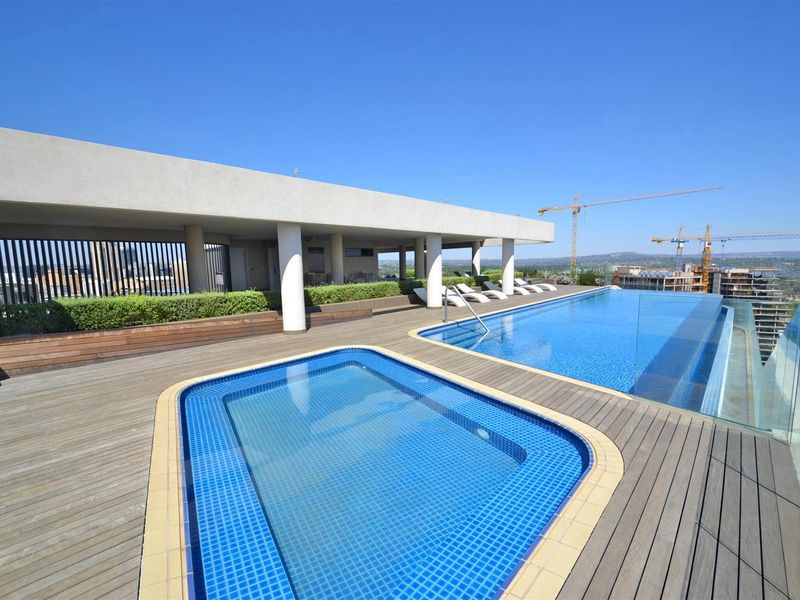 Rooftop terrace featuring an infinity pool, a separate plunge pool, timber decking, and panoramic views with a covered seating area.