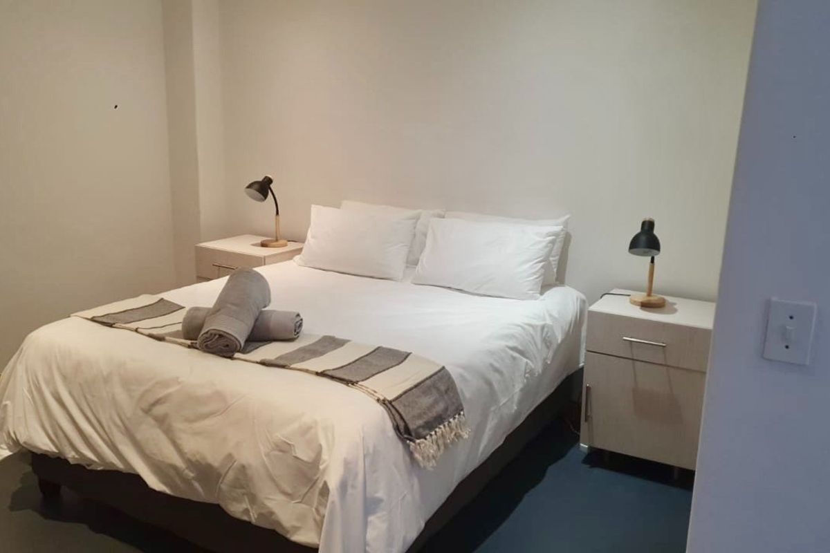 A simple bedroom featuring neutral walls and flooring, providing a clean and functional space for rest.