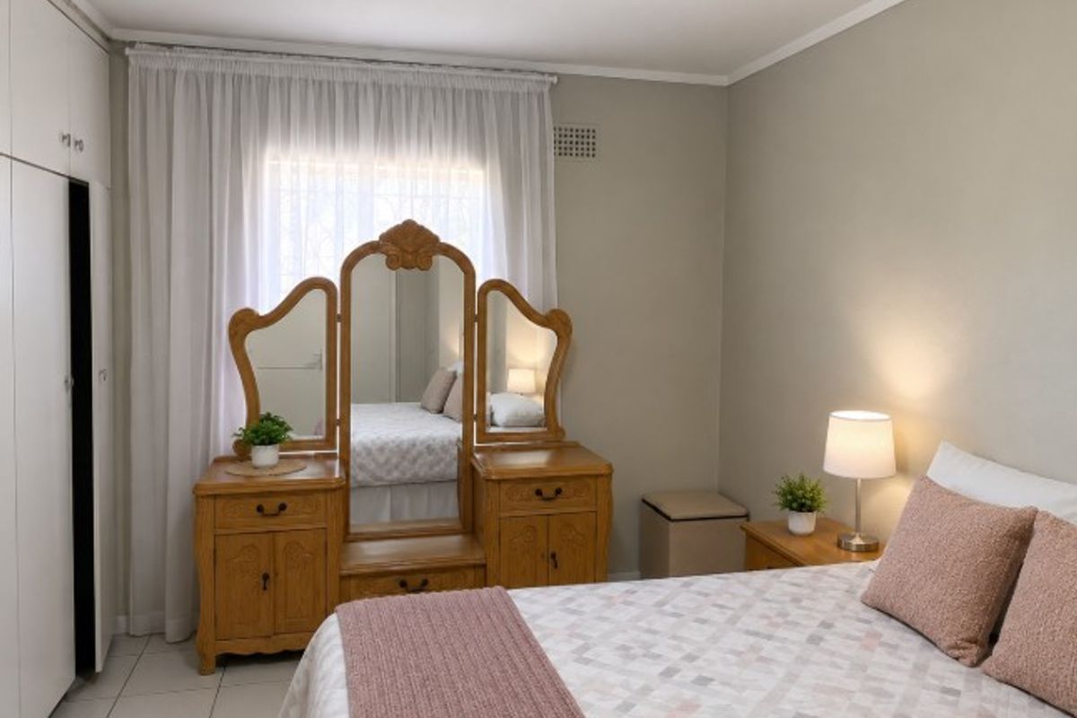 A well-maintained bedroom featuring built-in cupboards, neutral wall finishes, and tiled flooring, offering a clean and functional living space.