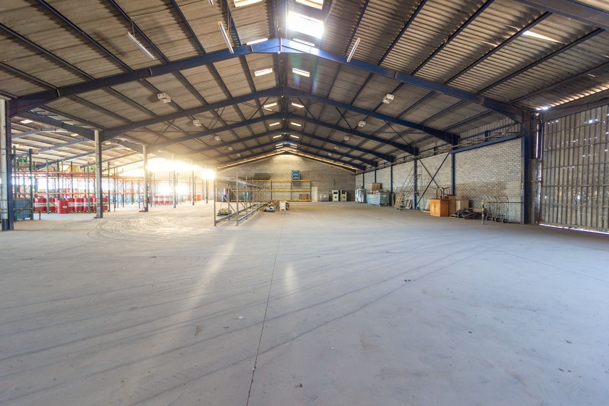 Spacious industrial warehouse featuring a high-clearance steel portal frame, concrete flooring, and natural light provided by integrated roof skylights.