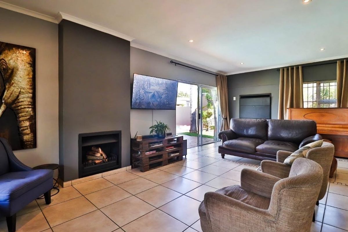 Spacious living room featuring a built-in fireplace, tiled flooring, and large sliding glass doors providing direct access to the outdoor area.