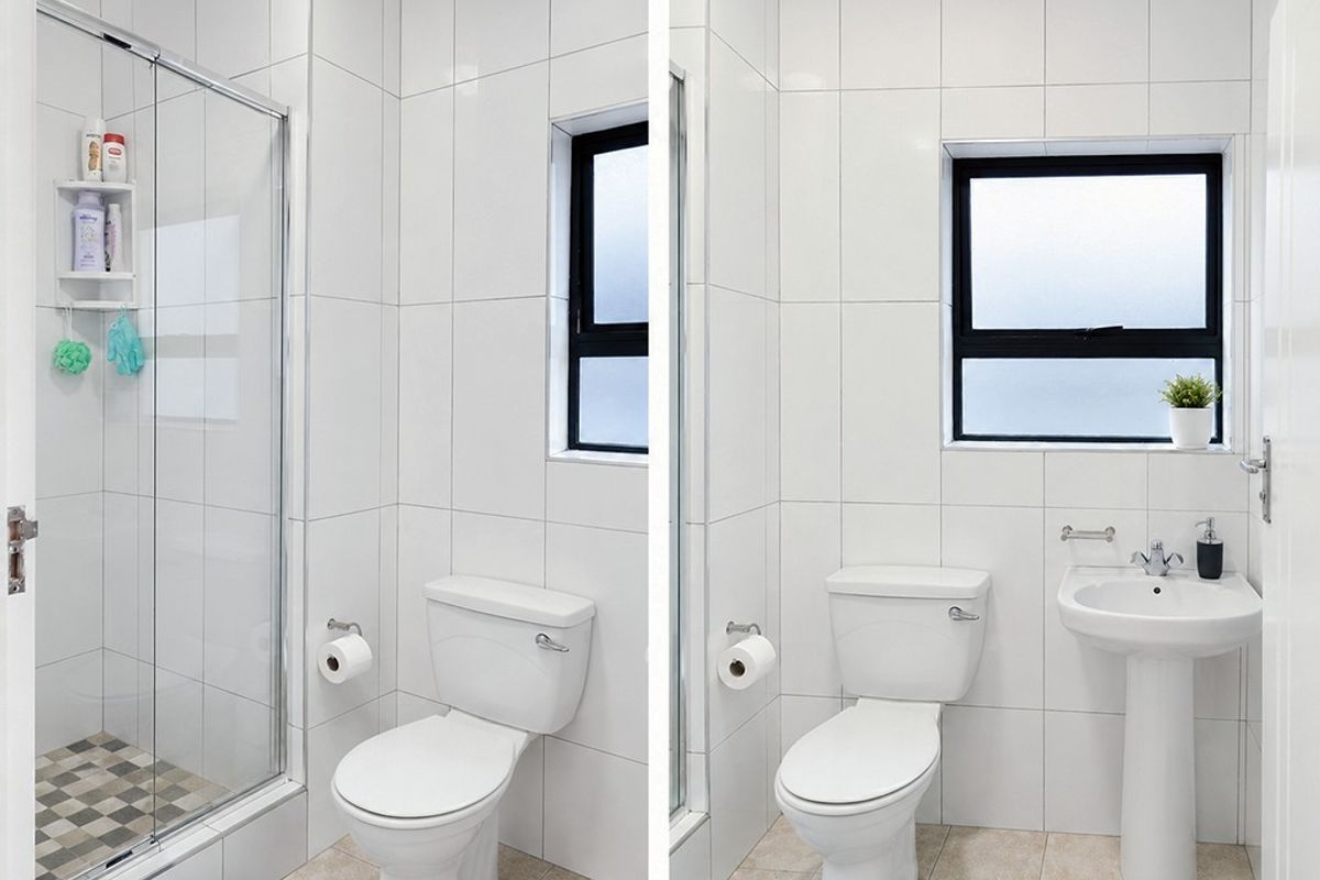 A clean, modern bathroom featuring a glass-enclosed shower, pedestal basin, and white tiled finishes with a frosted window for privacy.