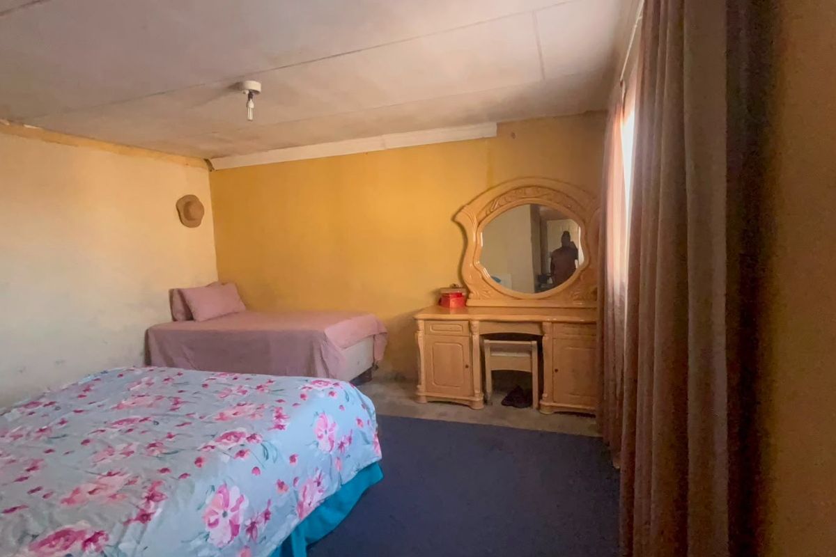 A bedroom featuring basic finishes, requiring cosmetic updates to the walls and ceiling to improve the overall aesthetic and condition.