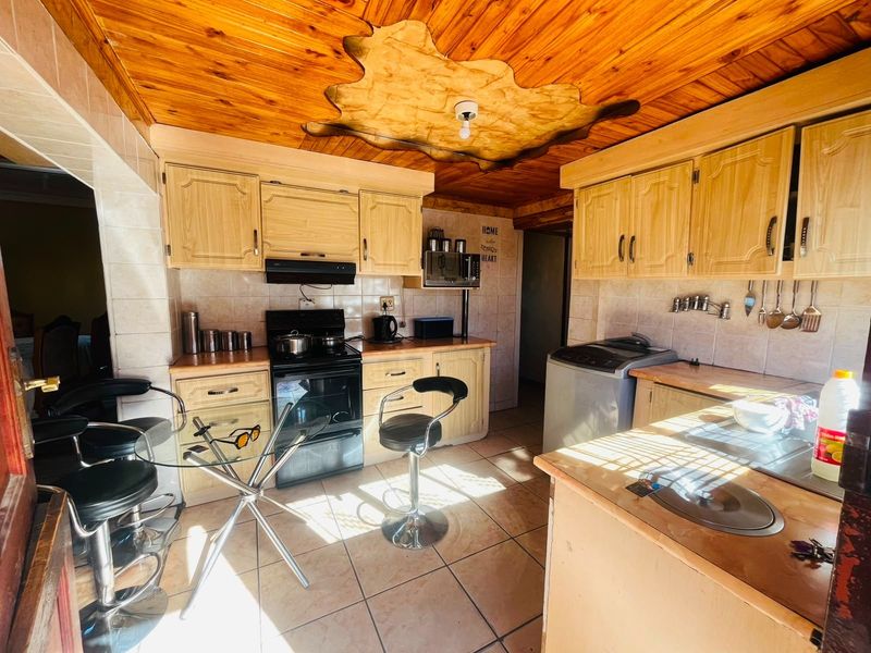 A functional kitchen featuring wooden ceiling paneling, tiled backsplash, built-in cabinetry, and a built-in oven with an extractor fan.
