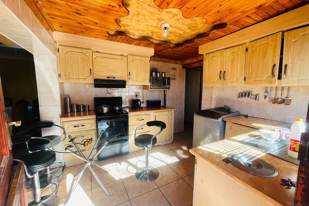 A functional kitchen featuring wooden ceiling paneling, tiled backsplash, built-in cabinetry, and a built-in oven with an extractor fan.