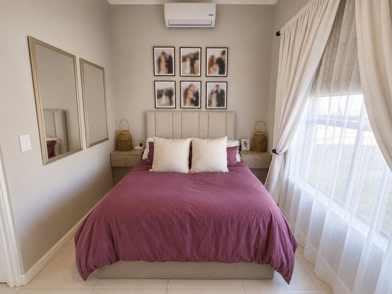 A well-maintained bedroom featuring tiled flooring, a wall-mounted air conditioning unit, and built-in bedside tables.