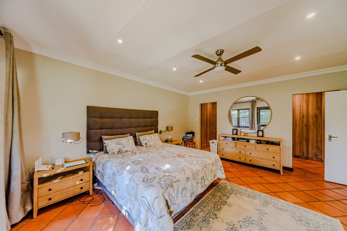 Spacious bedroom featuring terracotta floor tiles, recessed lighting, a ceiling fan, and built-in cupboard storage.
