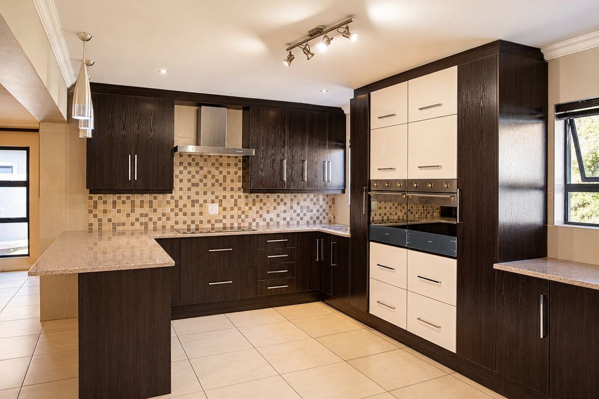 Modern kitchen featuring dark wood and white cabinetry, granite countertops, mosaic backsplash, built-in oven, and ceramic tile flooring.