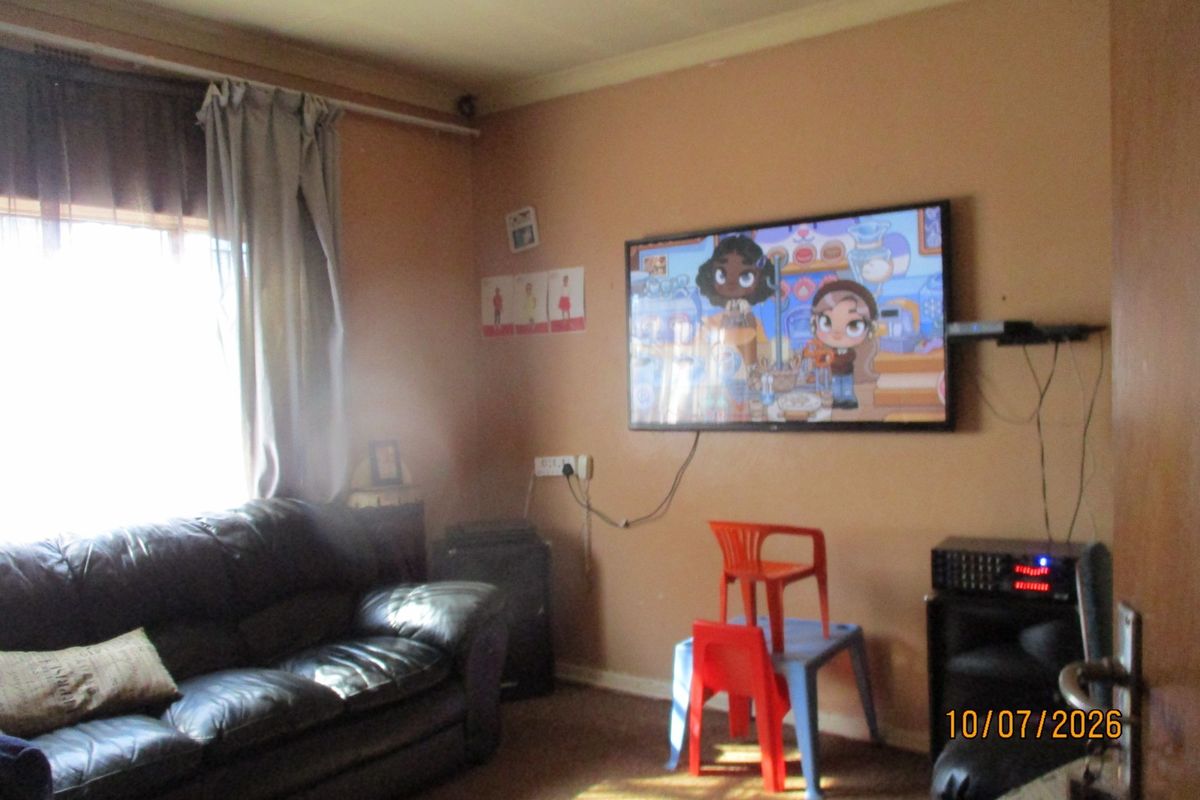 A living room featuring a wall-mounted television, curtain rod, and coving, requiring cosmetic updates to improve the overall aesthetic and finish.