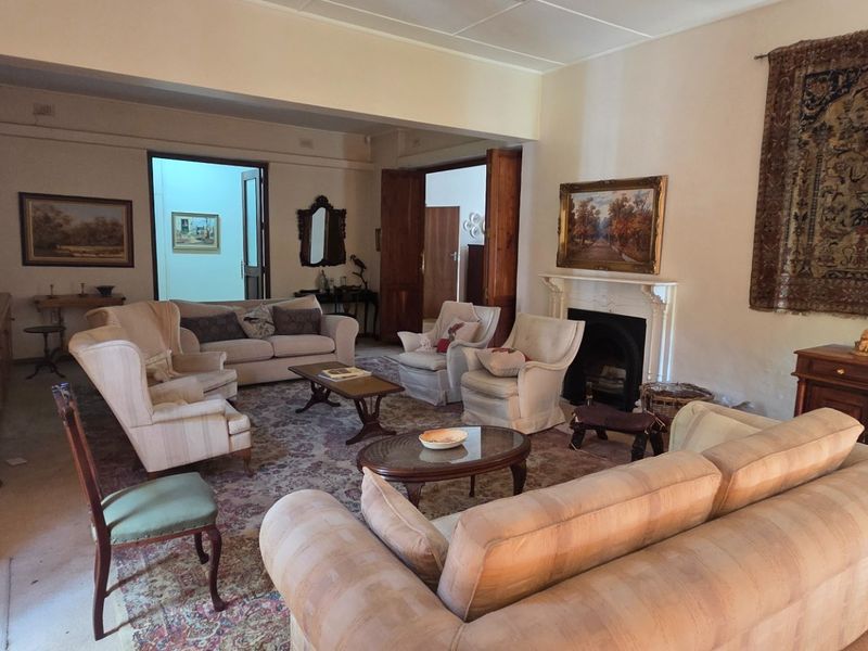 Spacious living room featuring a traditional fireplace with mantelpiece, built-in cabinetry, and classic double door access to adjacent rooms.