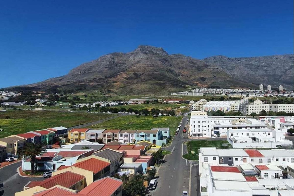 An elevated aerial view of the surrounding residential neighborhood and urban landscape with a prominent mountain backdrop.