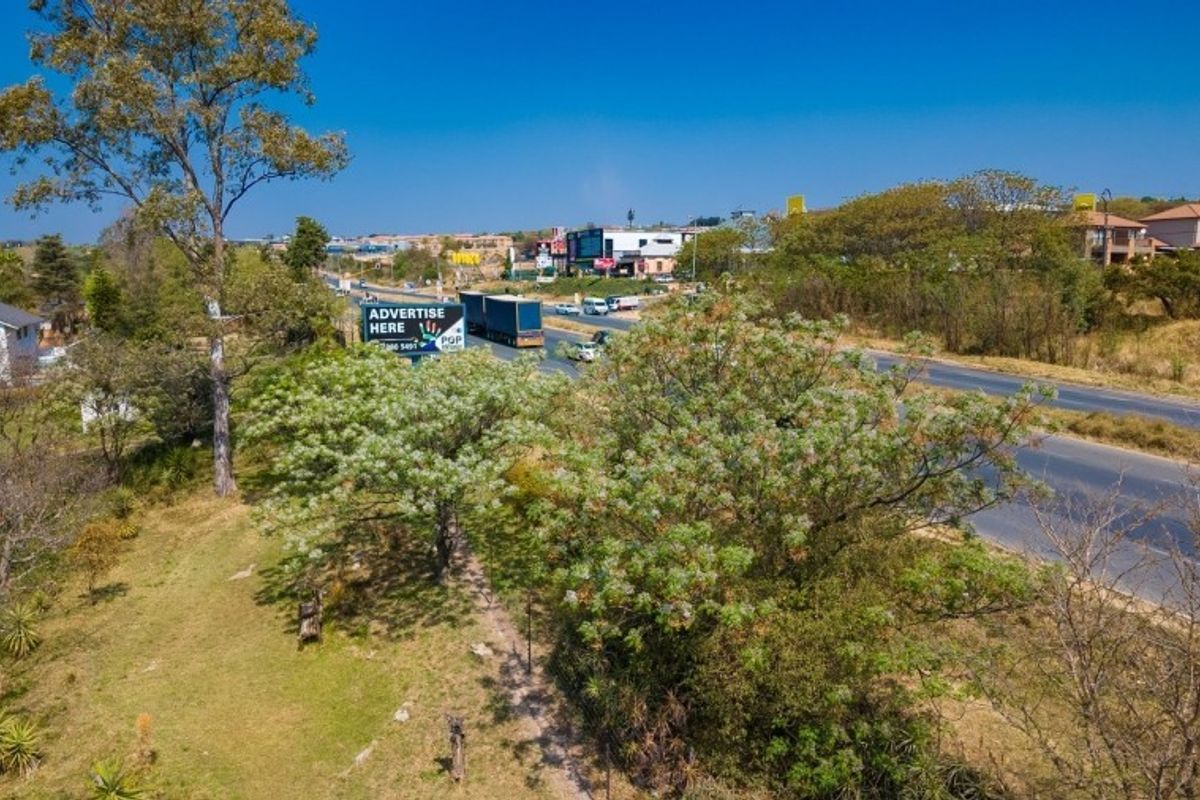 Aerial view of the property surroundings, showing proximity to the main road and local vegetation.