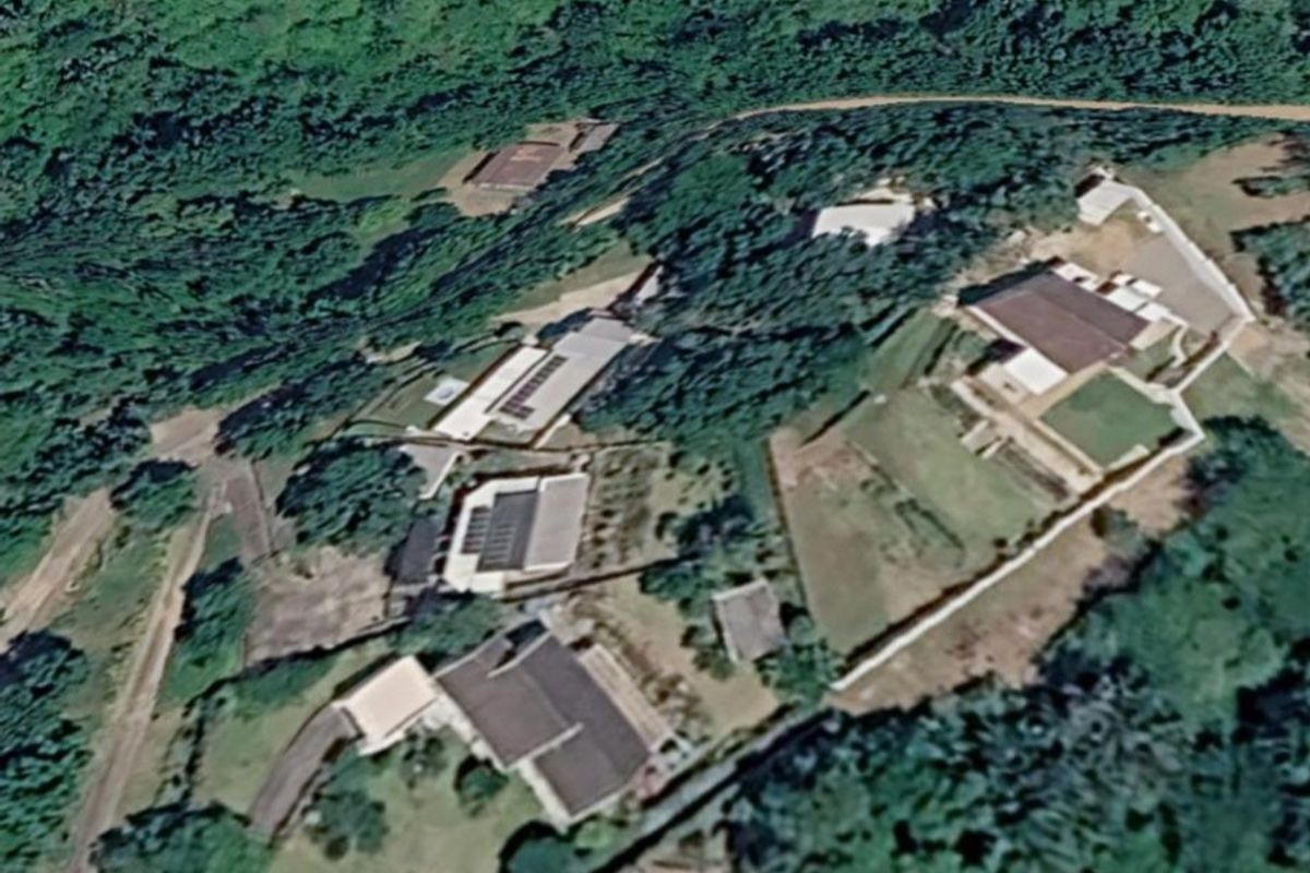 An aerial satellite view showing the property layout, surrounding vegetation, and access paths within the estate.