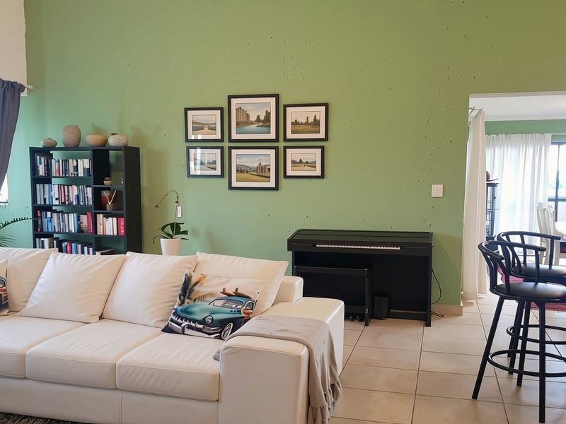 Open plan living area featuring tiled flooring and direct access to an adjoining space, with neutral wall finishes and integrated lighting.