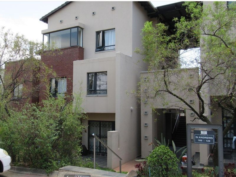 Front elevation of a multi-story apartment complex featuring a mix of brick and rendered finishes, external staircases, and security gates.