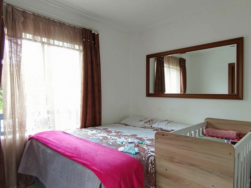 A functional bedroom featuring a large sliding glass door for natural light and a wall-mounted mirror.