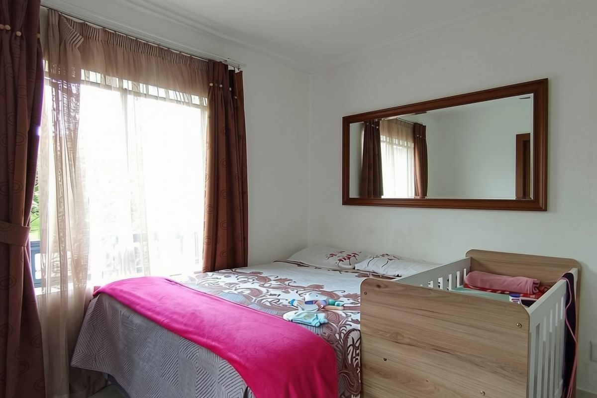 A functional bedroom featuring a large sliding glass door for natural light and a wall-mounted mirror.
