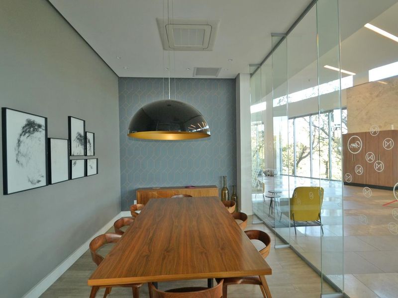 Modern dining room featuring a glass partition wall, feature wallpaper, and recessed ceiling lighting, creating a sophisticated and open atmosphere.