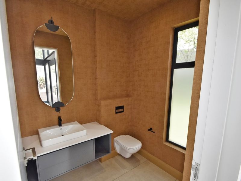 Modern guest bathroom featuring a wall-mounted vanity with vessel sink, wall-mounted toilet, and textured wall finishes.