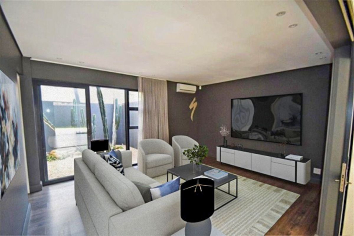 Modern living room featuring dark accent walls, laminate flooring, recessed lighting, and large sliding glass doors providing access to the outdoor area.