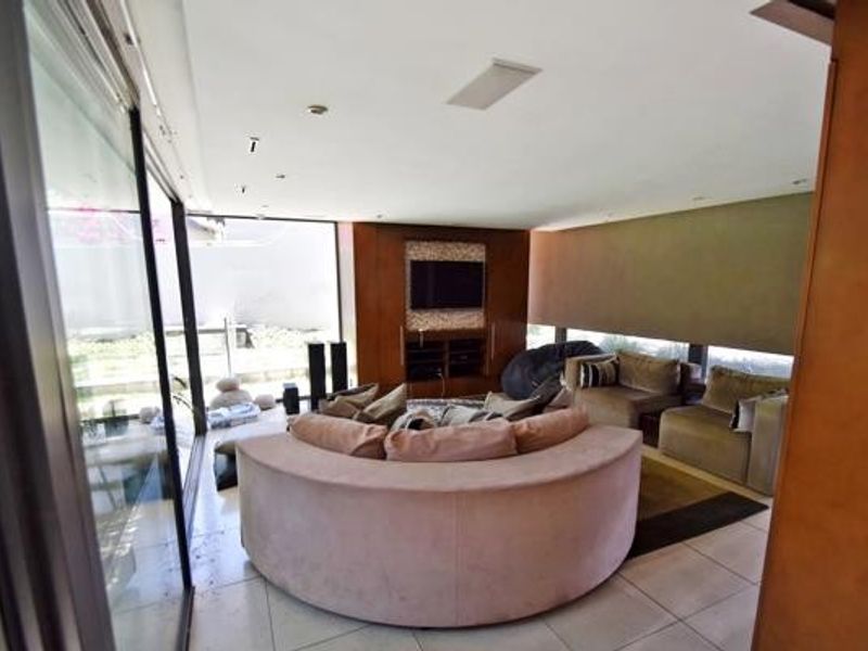 Spacious living room featuring large sliding glass doors for natural light, built-in cabinetry, and modern tiled flooring.