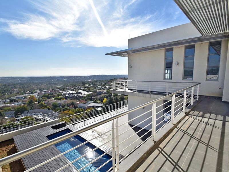 Spacious elevated balcony featuring tiled flooring, metal balustrades, and an integrated swimming pool with decking, offering expansive panoramic views.