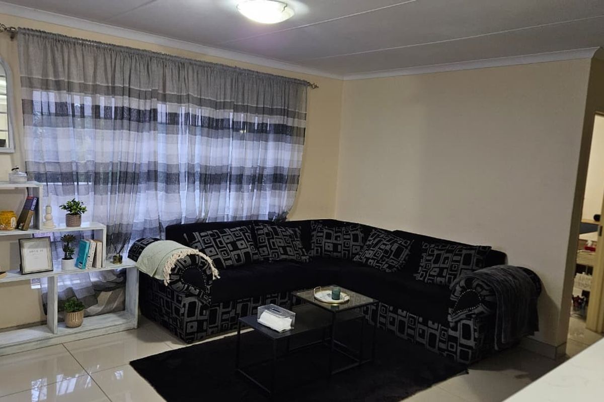 A living room featuring tiled flooring and a coved ceiling, providing a functional and neutral space for relaxation.