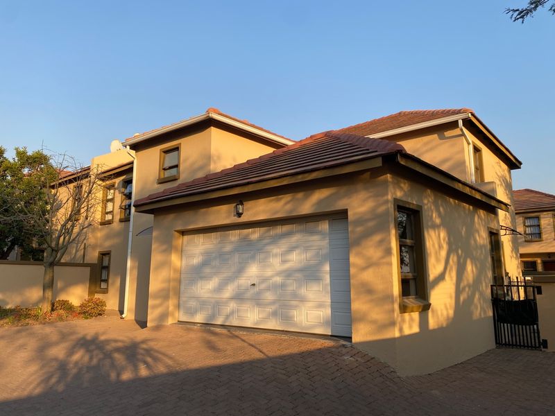 A well-maintained double-story residential property featuring a paved driveway, a secure garage, and a tiled roof exterior.