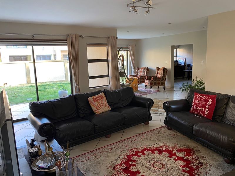 Spacious open-plan living area featuring tiled flooring, recessed lighting, and large sliding glass doors providing direct access to the rear garden.