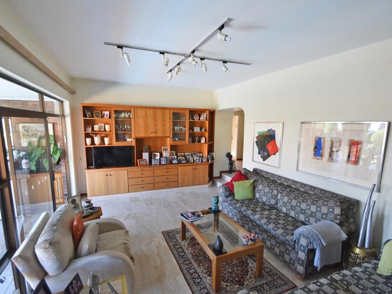 Spacious living room featuring built-in wooden cabinetry, tiled flooring, and large sliding glass doors providing access to the outdoor area.