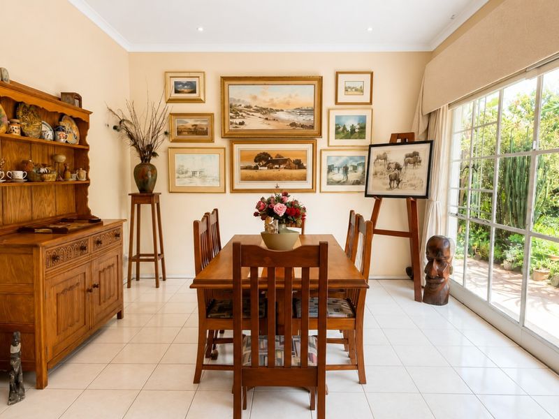 A bright dining room featuring tiled flooring and large sliding glass doors that provide natural light and access to the garden area.