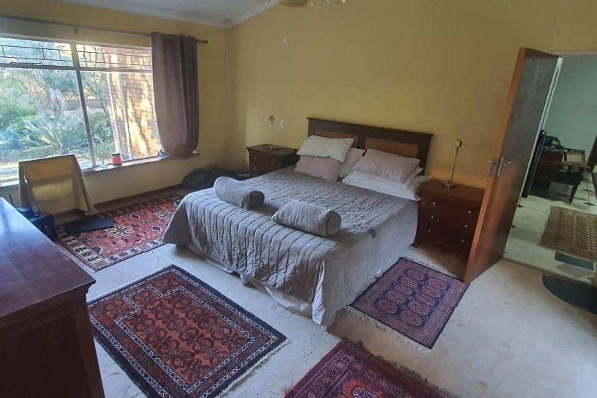 Spacious bedroom featuring large windows providing natural light and direct access to the hallway.