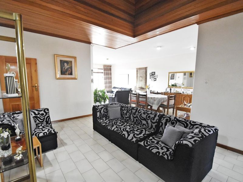 Spacious open-plan living and dining area featuring a distinctive timber-clad vaulted ceiling and neutral ceramic floor tiles throughout.