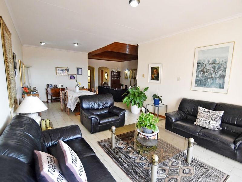 Spacious open-plan living and dining area featuring tiled flooring and recessed lighting, creating a versatile layout for comfortable family living.
