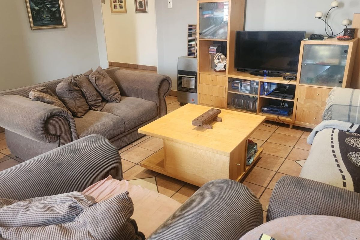 A comfortable living room featuring ceramic floor tiles and a built-in gas heater, providing a functional and lived-in space.
